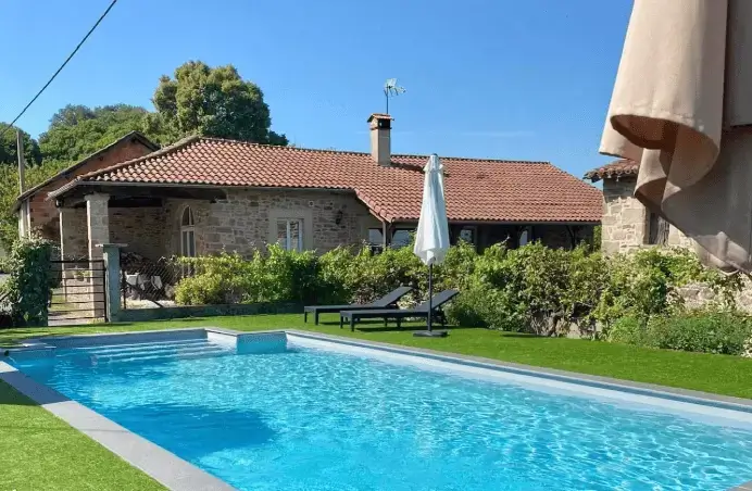 Vue sur une piscine et une maison d'ancienne architecture.