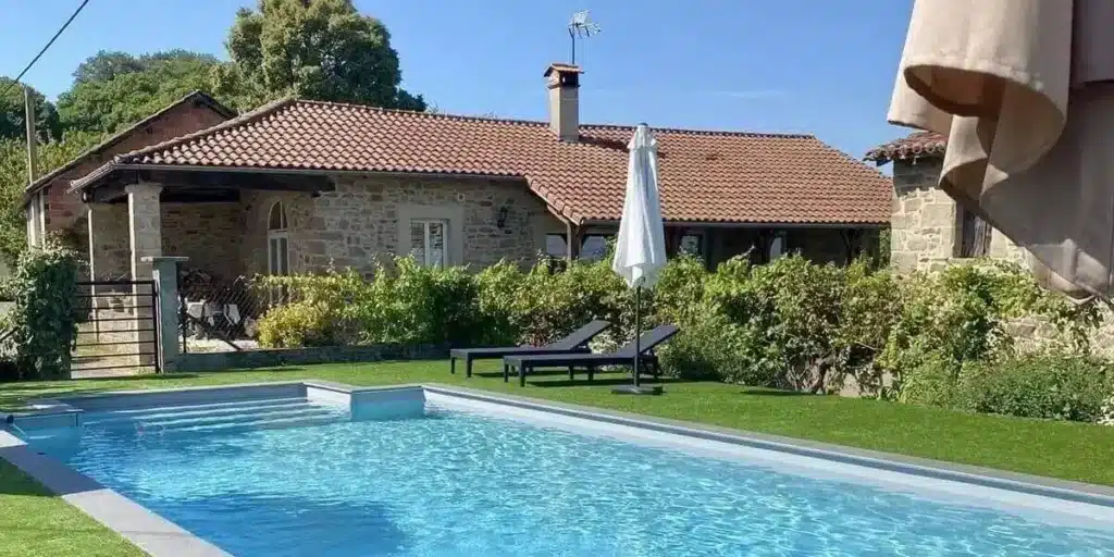 Une maison avec une maginifique jardin et une piscine.