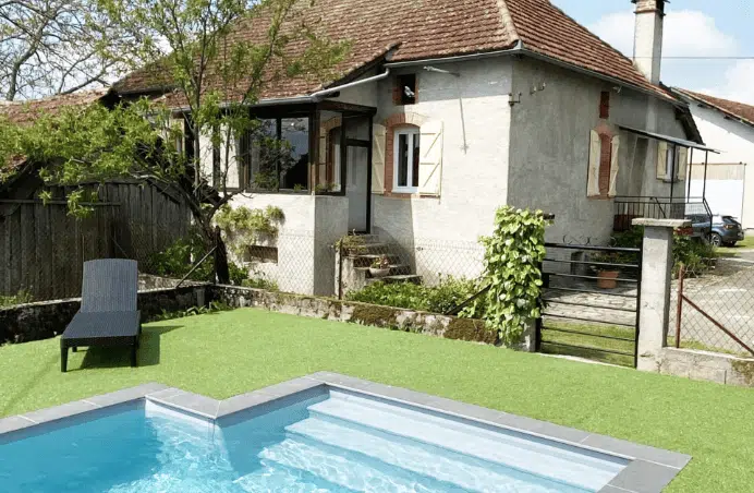 Vue sur une maison et une bord de piscine.
